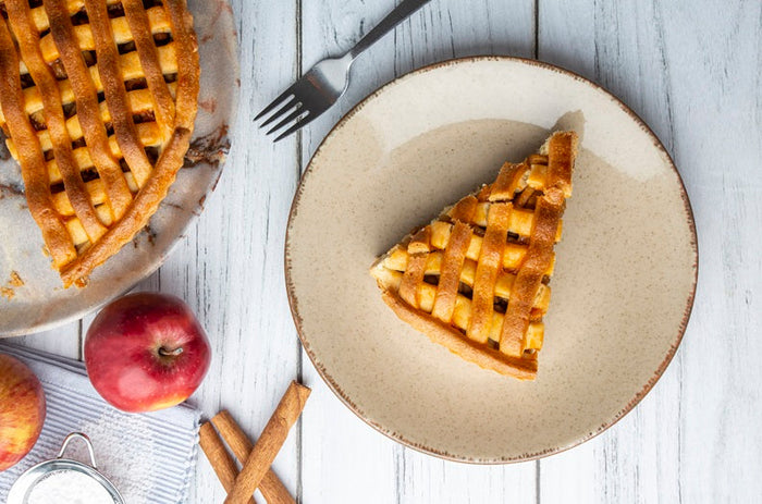 Freshly baked apple pie slice with fork on wooden table – autumnal recipe featuring Ceylon cinnamon