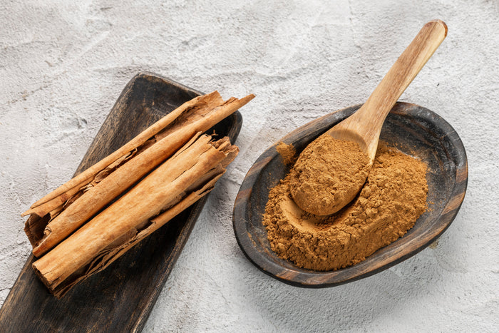 Ceylon cinnamon sticks and ground powder in rustic wooden bowl – whole vs ground spices compared